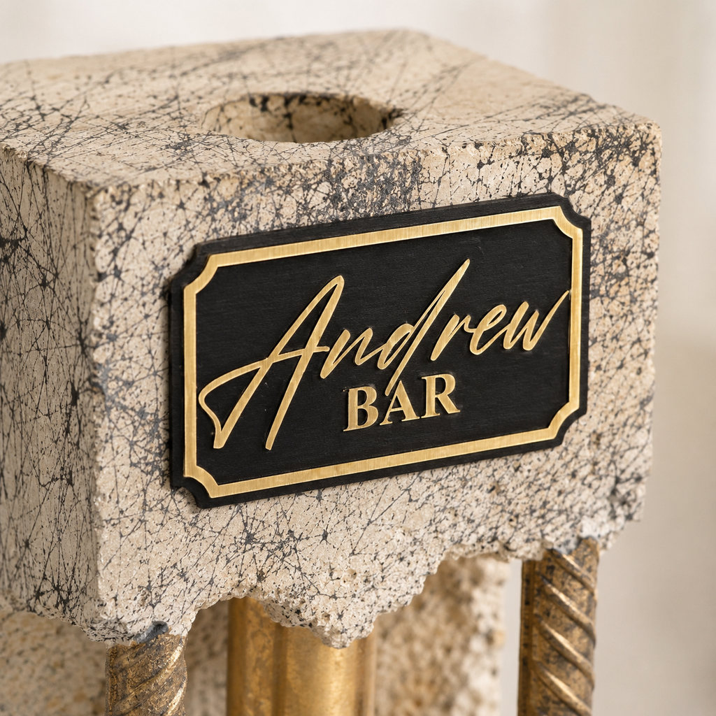 Close-up of custom black and gold engraved plaque on handmade concrete liquor dispenser