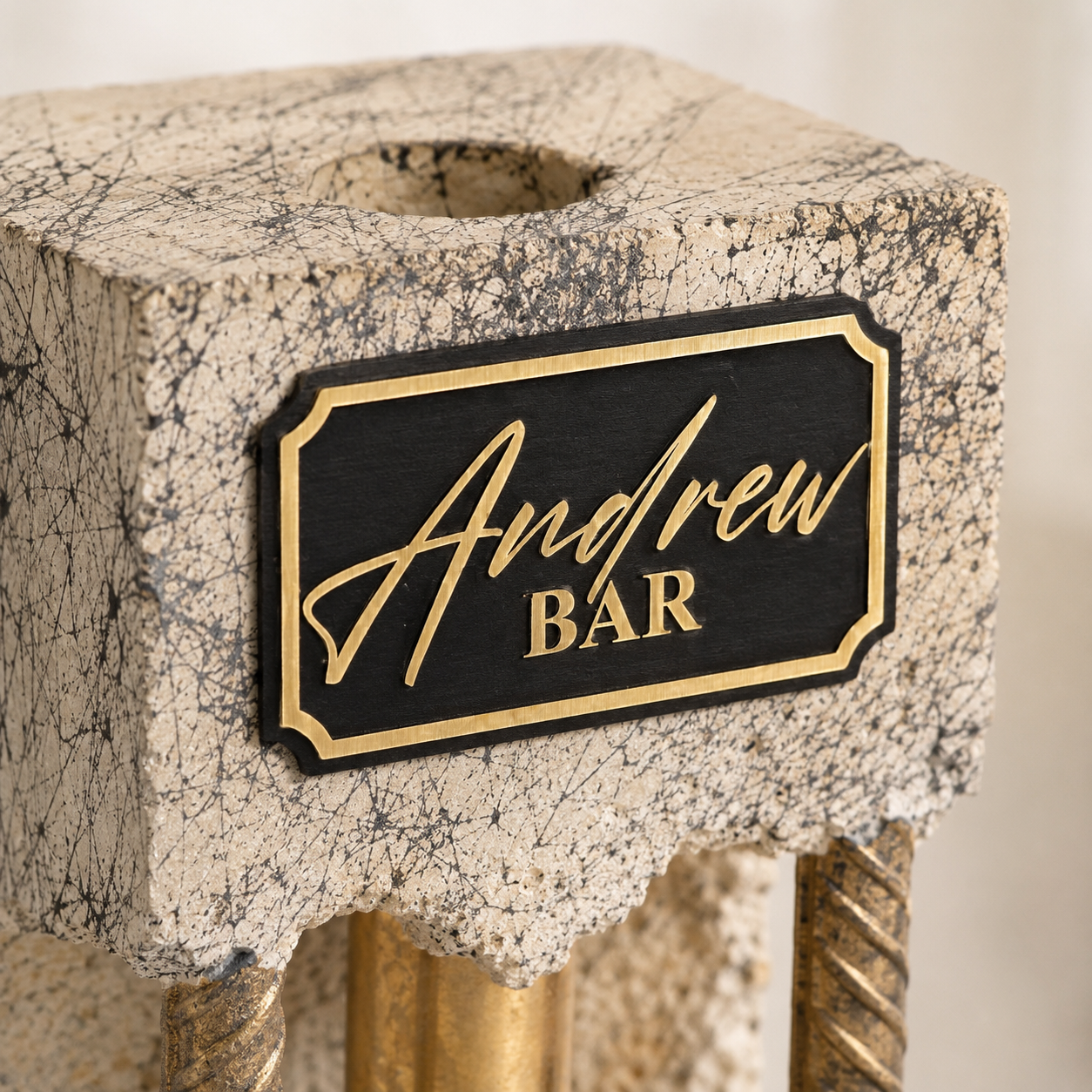 Close-up of custom black and gold engraved plaque on handmade concrete liquor dispenser