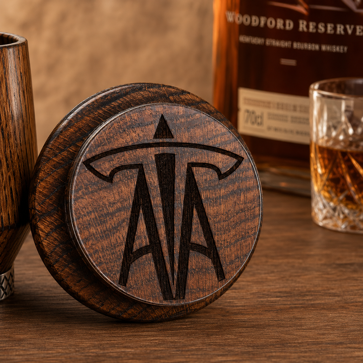 Close-up of custom laser engraved logo on the bottom of a solid oak whiskey tumbler
