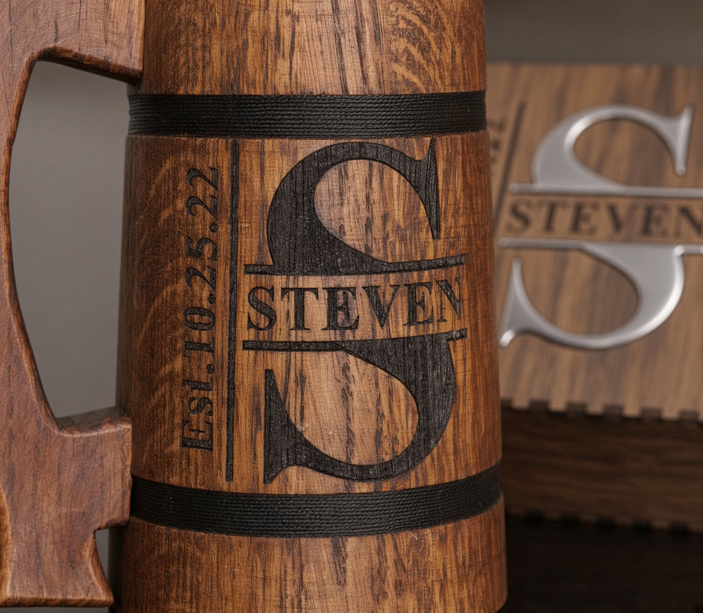 Close-up of the Steven split monogram engraved directly into an oak beer mug between two decorative black bands.