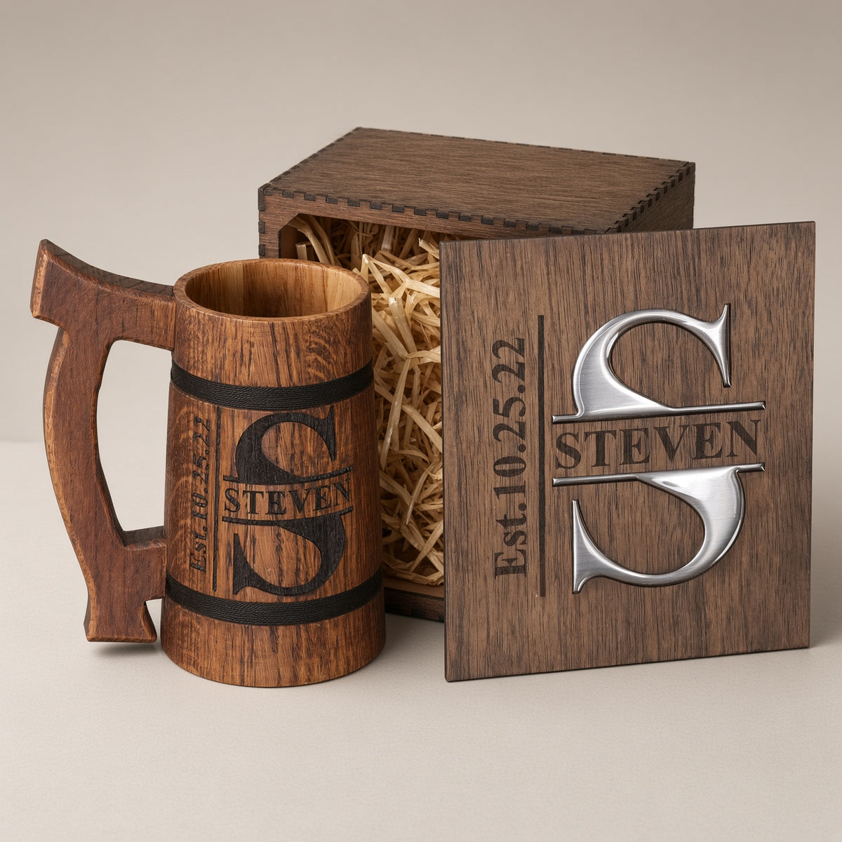 Personalized oak beer mug with an engraved Steven split monogram beside a wooden gift box with silver-colored resin inlay.