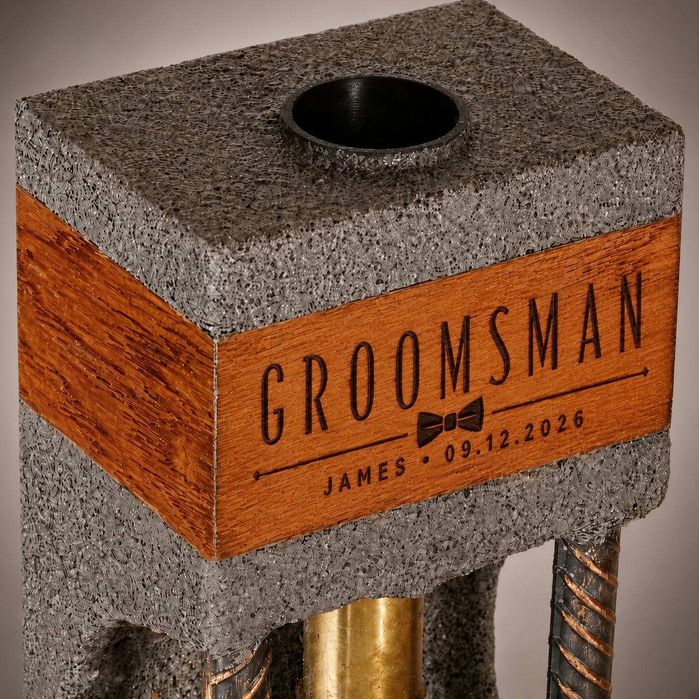 Close-up of personalized groomsman engraving on the oak band of a concrete whiskey dispenser