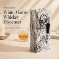 Personalized white marble whiskey dispenser with engraved aluminum plaque and silver-tone tap, styled with a whiskey glass for a custom bar gift.
