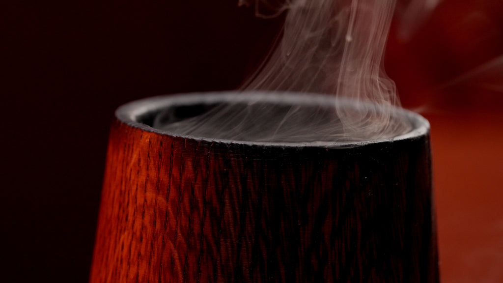 Close-up video of a charred oak whiskey glass showing the dark interior and wood texture.