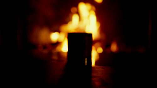 Video of a handcrafted charred oak bourbon tumbler with warm firelight and rustic atmosphere.