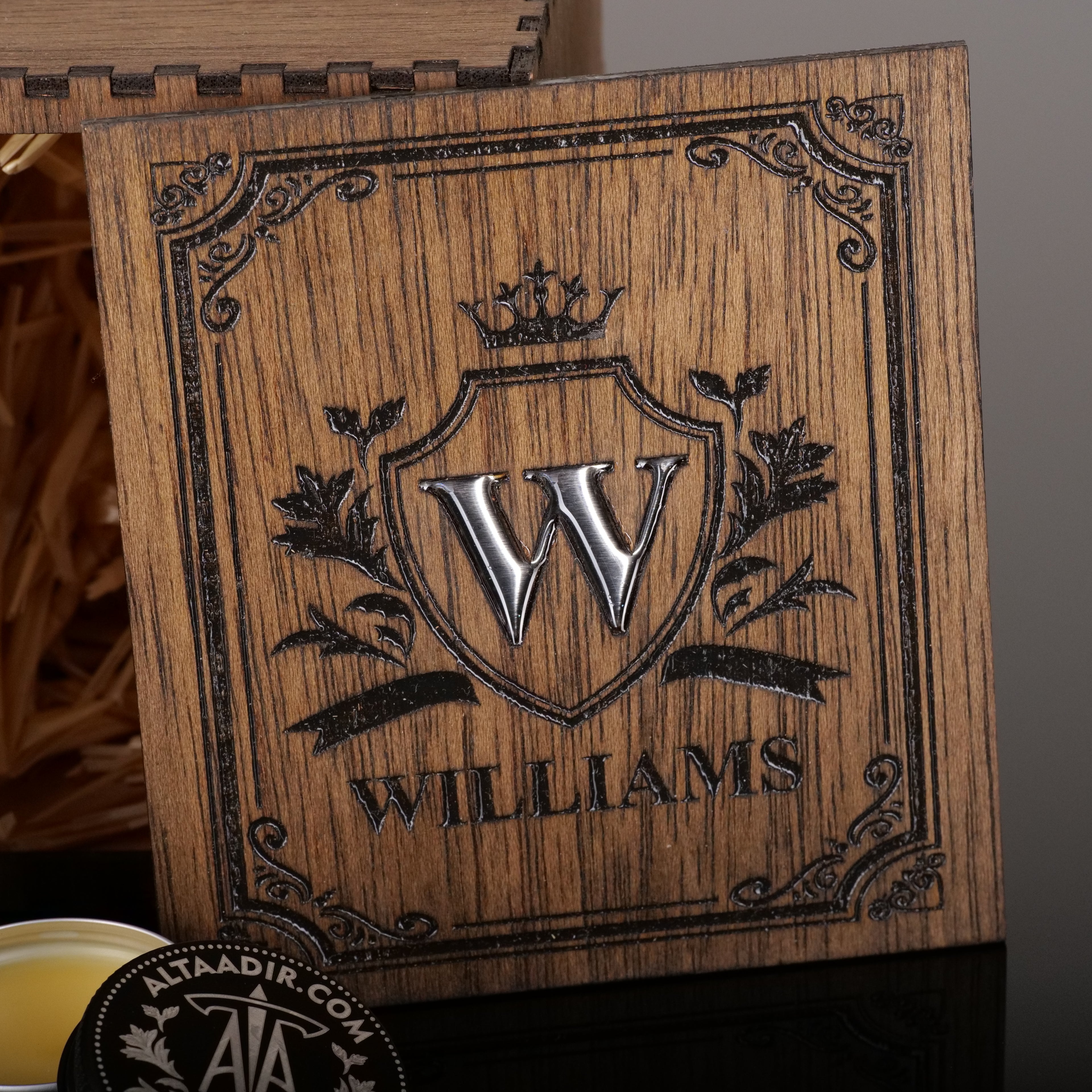 Close-up of a wooden gift box lid with deep engraving and a silver-toned epoxy resin Williams monogram inlay.