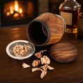 Lifestyle photo of charred oak whiskey smoker kit with engraved glass, lid, oak chips, and bar setting.