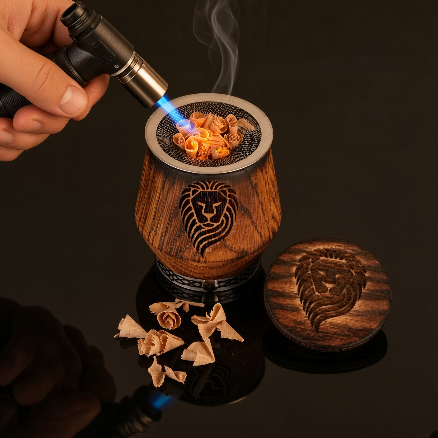 Mini torch igniting oak chips in a charred oak whiskey smoker glass with engraved design.