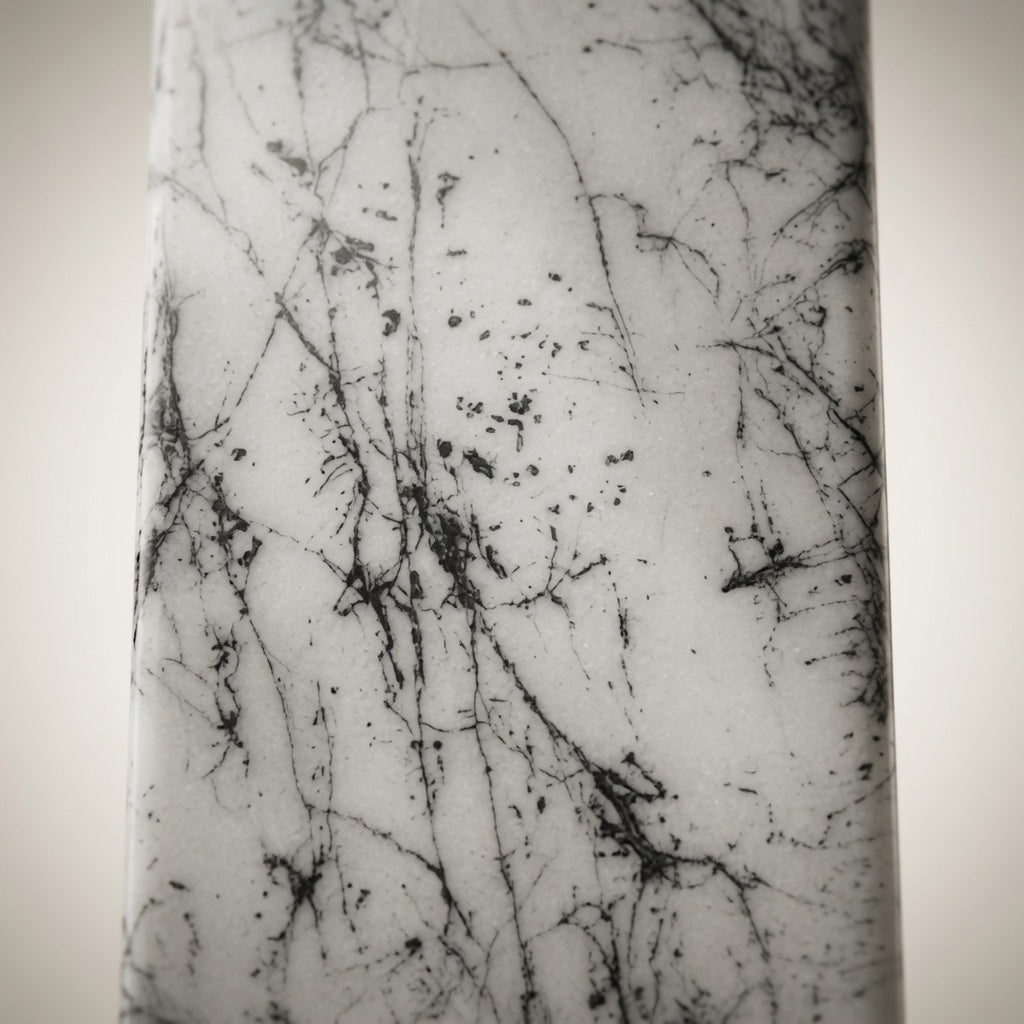 Close-up of white marble whiskey dispenser with hand-decorated black abstract pattern and natural marble-style texture.